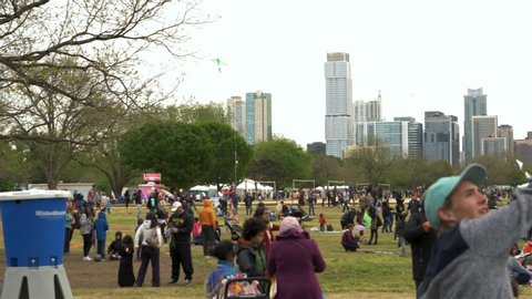 Austin , Texas / United States - 03 31 2019: Families and friends gather in crowds to fly kites in a large city park during a kite festival.