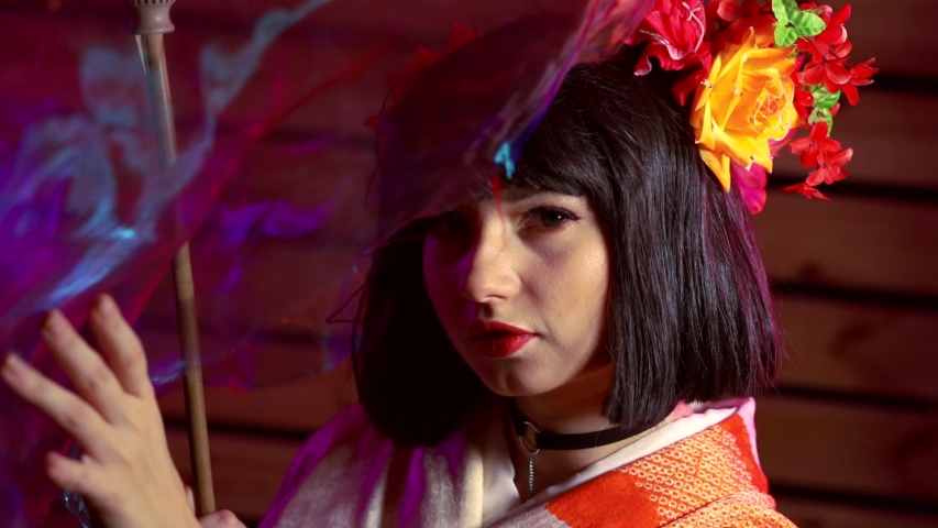 charming brunette woman dressed in kimono, holding decorative umbrella