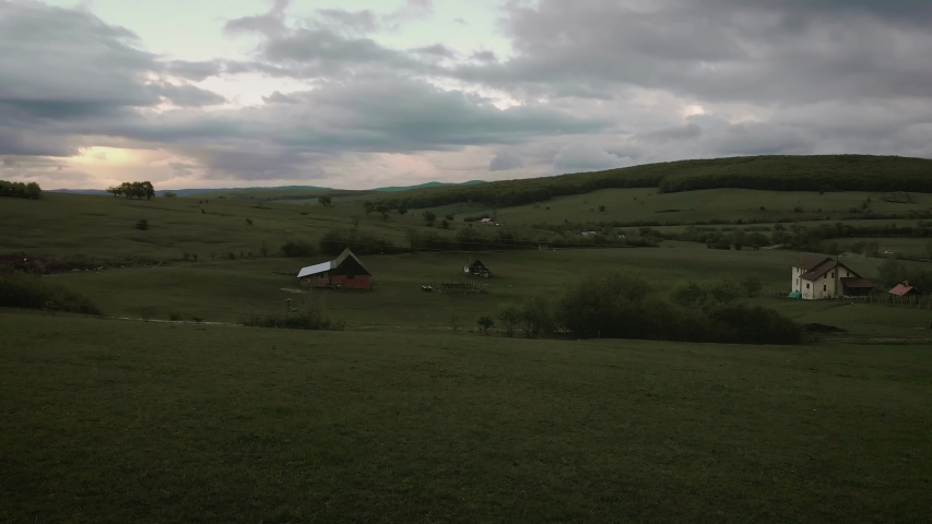 Drone footage with amazing view over green fields in Romania at sunset