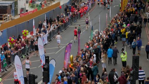 London / United Kingdom (UK) - 04 28 2019: Aerial over crowd of people watching the Virgin Money London Marathon race through the city alongside the river Thames. Tilt up revealing Big Ben Elizabeth t