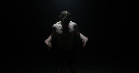 Weightlifter Dead Lifting And Training Exercising As Smoke Falls On Him In A Dark Background Shirtless