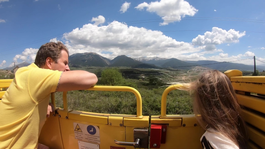 Father and his daughter are traveling "Le Train Jaune" road in Pyrenees, France.