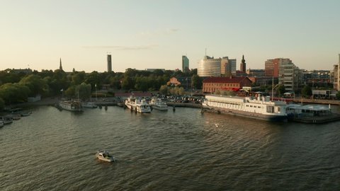 Aerial video of Vasteras city harbour during sunset. Boats, ferrys & buildings. Beautiful light over lake Malaren.