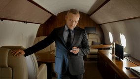 Portrait of entrepreneur with phone inside of expensive business jet. Confident businessman typing messages in cell phone using 4g internet connection in the air. - Powered by Shutterstock - Get 15% off with code: PIKWIZARD15
