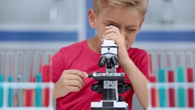 Focus pull of boy using microscope in laboratory