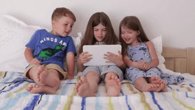 happy, smiling children play games on the tablet, watch cartoons, laugh