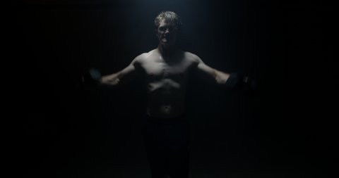  Male In A Dark Background Lifting Weights On Spotlight Preparing For Big Match 