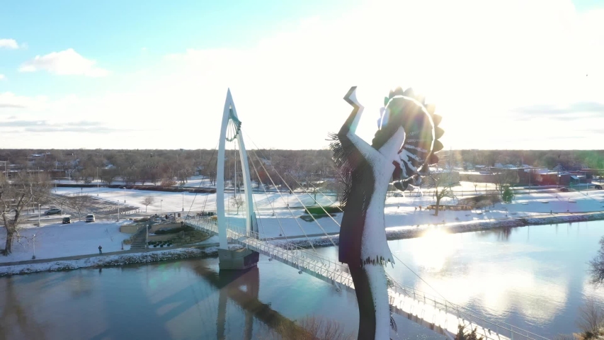 Aerial video during winter with snow on the Keeper of the Plains near downtown Wichita, Kansas near sunset.
