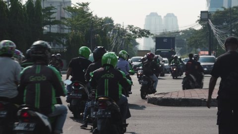 Busy street scene in Jakarta, Lots of motorbikes travelling down a road