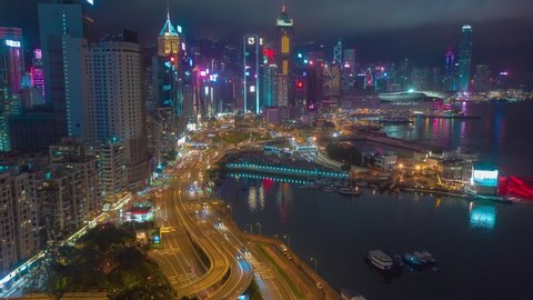 Aerial drone hyper lapse or time lapse over Hong Kong Victoria Harbor at night. Central distinct of Hong Kong shot by 4K resolution drone, Hong Kong is the most densely populated place in the world.