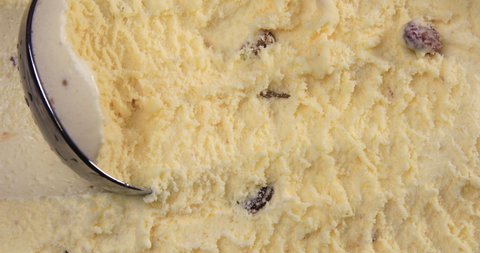 Top view of vanilla flavour ice cream with raisins and scoop in box 4k