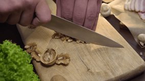 Close up video: chef cuts walnuts on the wooden board, cooking salad, vitamin vegetarian food, chopping the nuts, ingredients for cooking, Full HD Prores 422 HQ
