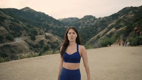 Twin-sisters ready for workout, motivational video, confidently looking into a distance , hiking on Los Angeles hills.