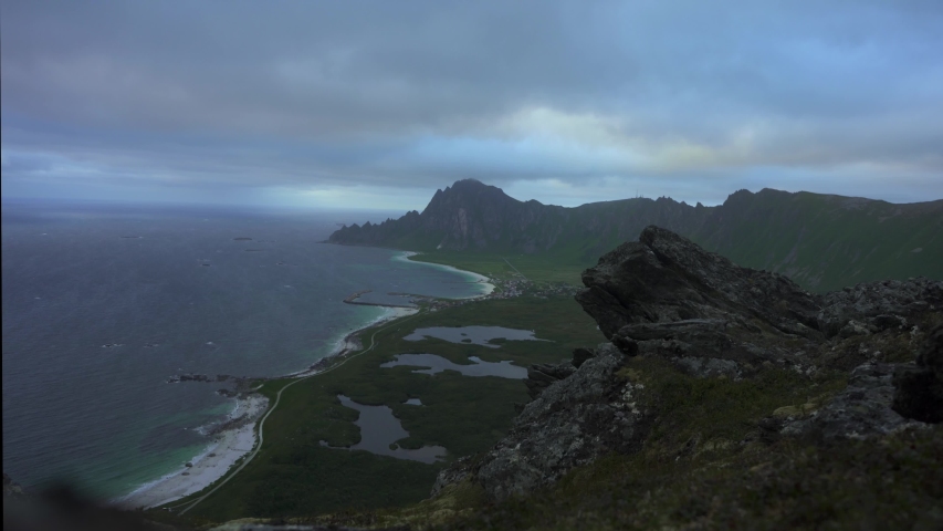 
Man admires ocean beach aerial view solo traveling active lifestyle hiking adventure. Located near Bleik is a fishing village on the northwestern part of the island of Andoya, in Nordland county, 