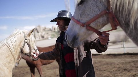 Cappadocia / Turkey - November 10 2015: A horse  stableman takes care of horses.  a horse stableman clean the horses.