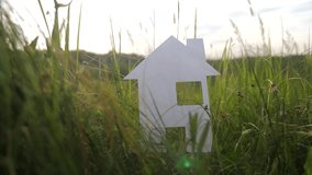 building happy family construction house lifestyle concept. paper house stands in the green grass in nature. symbol life ecology video