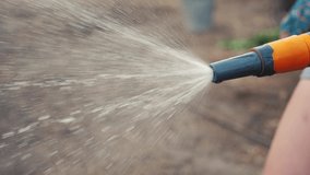 gardening garden care concept. splashing water slow motion video . woman holding a garden hose watering. Gardener lifestyle the vegetable with watering hose and water sprayer