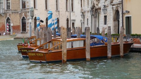 Venice , Veneto / Italy - 07 21 2018: Venice, Italy – July 21, 2018: Wooden boats tied up along a Venice canal.