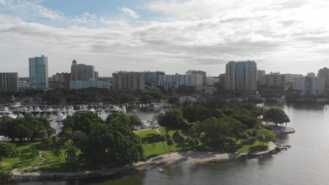 Beautiful downtown Sarasota, Florida as seen from a drone. Lush green waterfront park and harbor are visible in the clear morning light