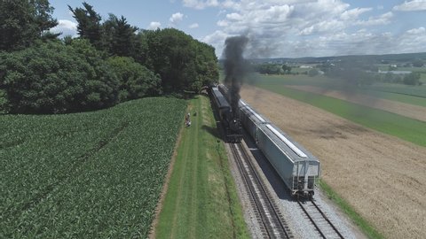 Aerial View of Farmlands and Countryside with a Vintage Steam Train Puffing up to Start up on a Sunny Summer Day Vídeo Stock