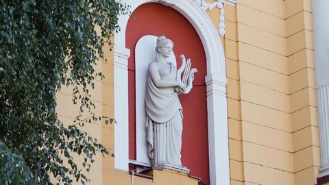 Terpsichore Muse Statue holding a lyre at a theater building facade. Performing arts