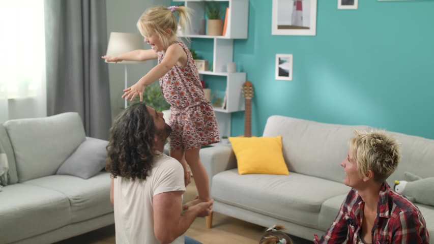Daughter standing balancing on dads hands | Shutterstock HD Video #1034851331