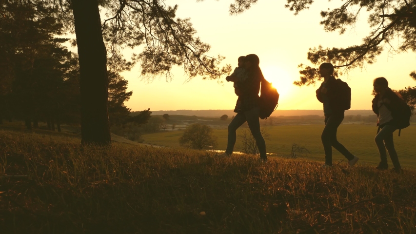 Family with children travel with backpacks at sunset. Mom, dad and daughters on a hike. Teamwork. Hiker Girl. Free rest. Hiking. Vacation. Weekend with family out of town | Shutterstock HD Video #1034862245