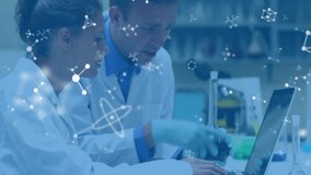 Animation of a male and a female Caucasian scientist seen waist up, side on, talking in a laboratory, using a laptop computer and holding a flask of liquid, while white molecular structures float in - Powered by Shutterstock - Get 15% off with code: PIKWIZARD15