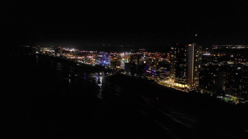 Aerial night approach Myrtle Beach South Carolina USA pier and skywheel