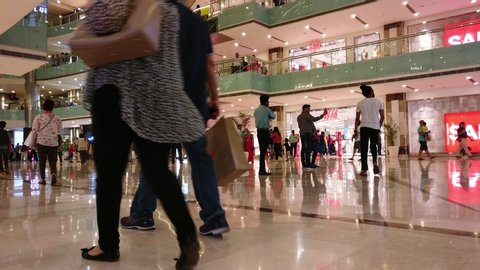 Gurgaon, Delhi, India - circa 2019: Low point of view POV shot showing shoppers, train ride, branded outlets and escalators in one of the top malls in gurgaon delhi. This shows the crowd of indian