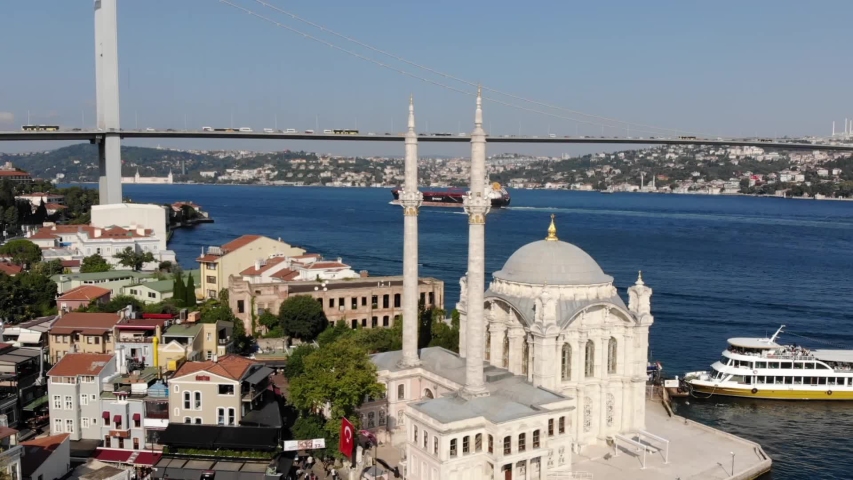 Aerial shot of Grand Mecidiye Mosque in Istanbul Ortakoy. Istanbul silhouette, bridge and ferries in the bakcground. (Ortaköy Cami)