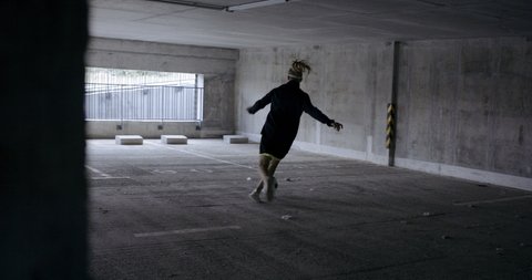 HANDHELD Teenager girl soccer player practicing kicks and moves inside empty covered parking garage. 4K UHD 60 FPS RAW graded footage Vídeo Stock