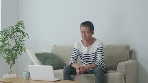 Middle aged asian man having a low back pain.