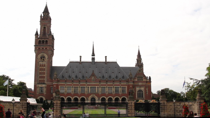 Peace Palace in the Hague with tourists - wide shot. It houses the International Court of Justice and is a popular tourist attraction in the Netherlands.