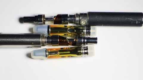 Cannabis Oil in Vape Pen, on White Background, Time Lapse. 