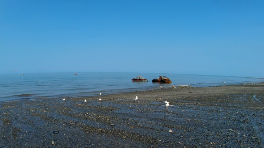A tractor is towing a fishing charter boat out of the surf at Deep Creek Recreational Area near Anchor Point, Alaska.