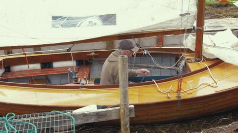 Sligo / Ireland - 08 10 2018: Man rigging clinker built Irish sail boat 'Galway Hooker'