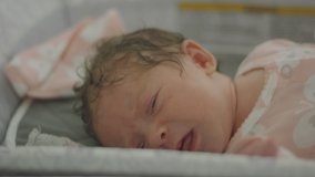 Slow motion shot of a newborn baby crying after a bath and with pjs on