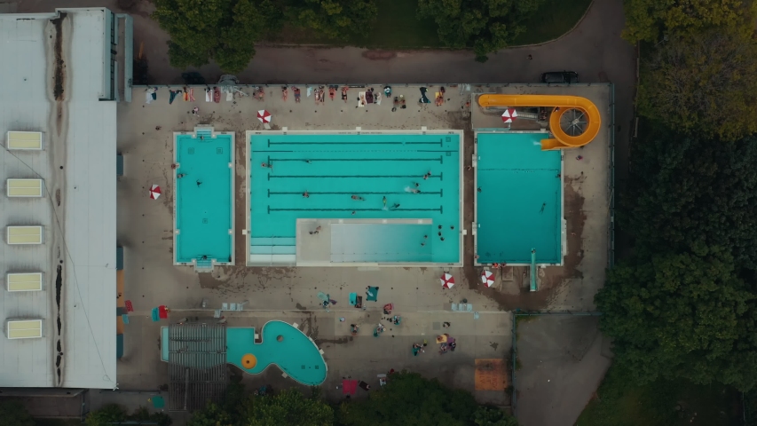 Aerial establishing shot of a public pool in a large city. Cinematic 4K footage.