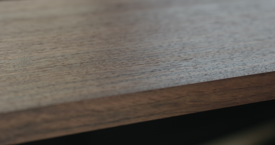 Slow motion woodworker checking oil finish on black walnut