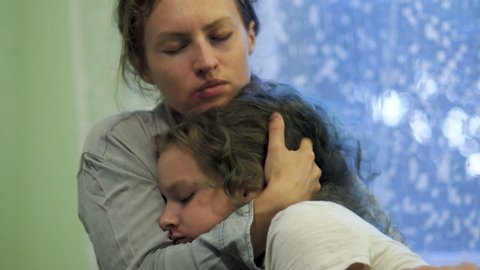 Beaten mother and daughter cry hugging. Indoor portrait, stop violence, eastern europe