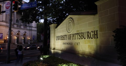 PITTSBURGH - Circa August, 2019 - A nighttime exterior establishing shot of the University of Pittsburgh sign in Oakland on PITT's campus. The Carnegie Museum in the background.  	