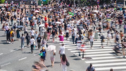 4K Timelapse high angle view of busy crowded pedestrian business people man and woman worker with tourist walking crossing street crosswalk with traffic driving cars at Shibuya, Tokyo City, Japan