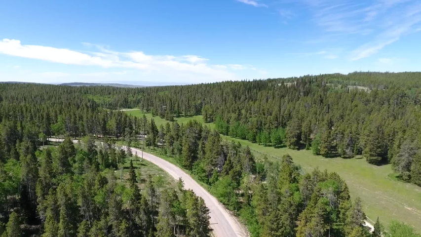 Road of Beartrap Meadow outskirts on sunny day. Wyoming USA. Aerial circle pan