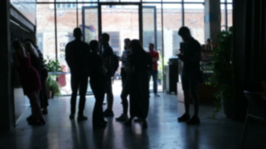 Young people stand in front of a cafe counter during lunch in a modern office building