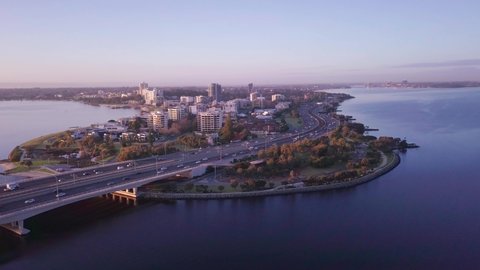 Aerial view of South Perth Foreshore district with circular camera motion (poi style) at sunrise, showing busy roads, traffic and morning commute.