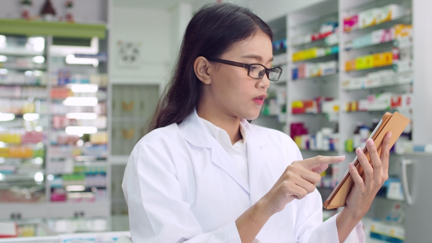 Beautiful asian pharmacist working in drugstore Royalty-Free Stock Footage #1034974301