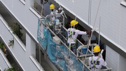 Woodlands / Singapore - August 12th 2019: A group of foreign workers are painting the building at a housing estate.