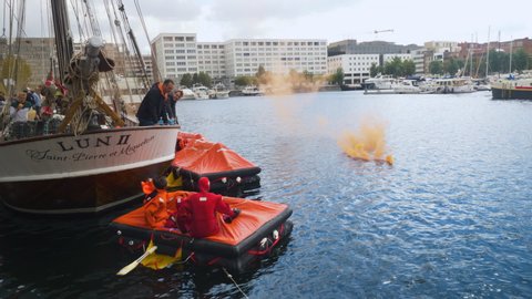 Antwerp / Belgium - 01 09 2018: Group of people in a life raft doing a safety training session with a smoke bomb