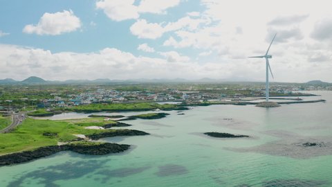 Drone View. Scenery of a seaside town with wind turbines running. Jeju Island in Korea.